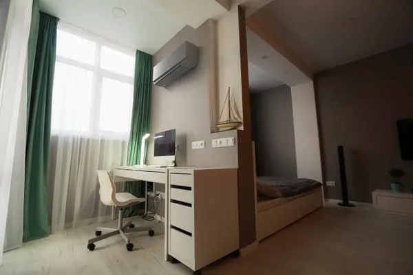 Home office with a wall-mounted air conditioning unit above the desk